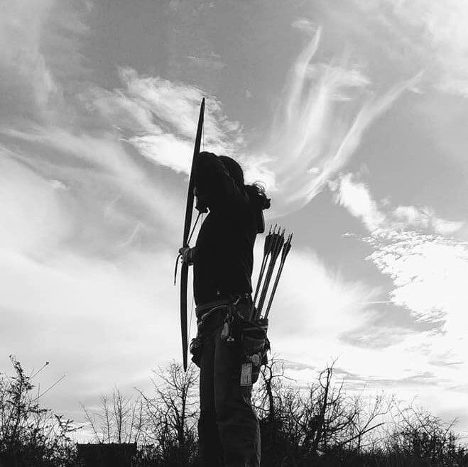 femme de dos qui tire à l'arc en noir et blanc