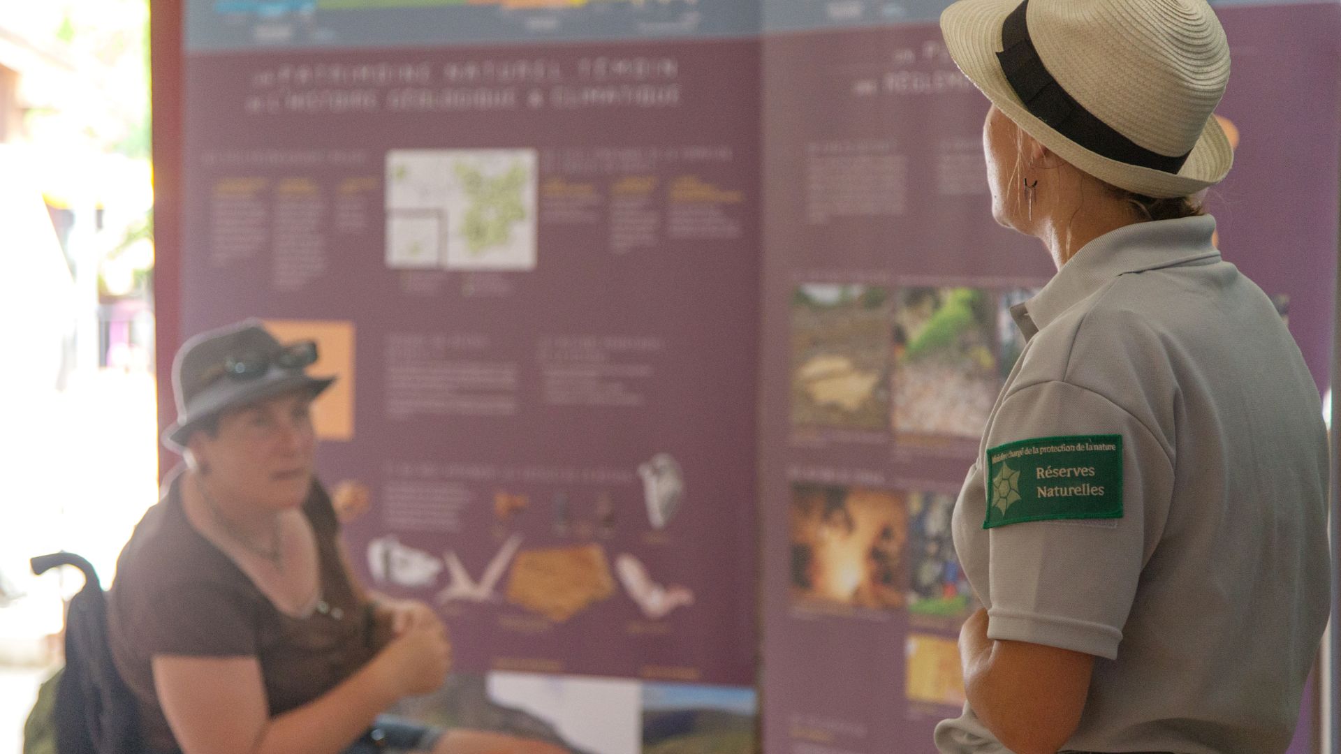 Photo d'une présentation lors d'une animation. L'animatrice présente une exposition de 5 panneaux qui décrit la Réserve naturelle géologique du Lot.