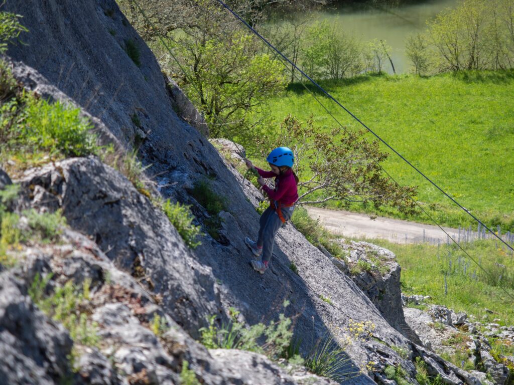 une enfant descend en position rappel